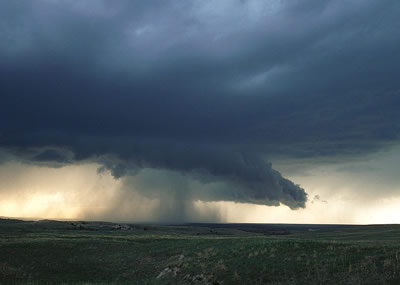 This photograph of a <a
  href="/earth/Atmosphere/clouds/cumulonimbus.html">cumulonimbus cloud</a> was taken on the <a
  href="/earth/grassland_eco.html">grasslands</a> of eastern Wyoming.
  Notice the <a
  href="/earth/Atmosphere/precipitation/rain.html">rain</a> and <a
  href="/earth/Atmosphere/precipitation/hail.html">hail</a> falling from this
  cloud! Cumulonimbus clouds form during <a
  href="/earth/Atmosphere/tstorm.html">thunderstorms</a>, when very warm, moist air rises into cold air. As this humid air rises, water vapor <a
  href="/earth/Water/condensation.html">condenses</a>,
  and forms huge <a
  href="/earth/Atmosphere/clouds/cumulonimbus.html">cumulonimbus</a>
  clouds.<p><small><em>         Photo courtesy of <a href="http://www.inclouds.com">Gregory Thompson</a></em></small></p>